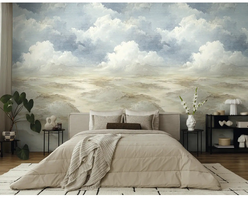 Fotobehang met een geschilderd landschap van wolken en heuvels in een moderne slaapkamer met beige bed en kamerplanten.