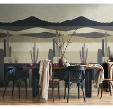 Fotobehang met woestijnlandschap, cactussen en bergen achter een houten eettafel met stoelen in een eetkamer.