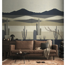 Vliesbehang met een gestileerd woestijnlandschap met bergen en cactussen in een modern ingerichte woonkamer met een bruine bank.