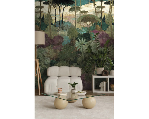 Moderne woonkamer met fotobehang van een gestileerd boslandschap met pijnbomen en palmen, een witte modulaire bank en een glazen tafel.