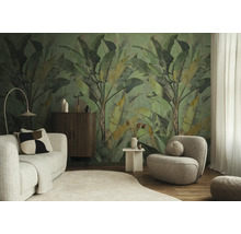 Woonkamer met vliesfotobehang met grote bananenbladeren, een getextureerde bank, een ronde fauteuil, een houten dressoir en een licht tapijt.