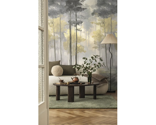 Fotobehang met bosmotief in een moderne woonkamer, impressionistische stijl met hoge bomen, lichte bank en donkere houten salontafel.