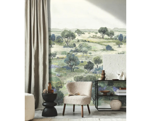 Fotobehang met geschilderd landschapsmotief van bomen en struiken in een modern ingerichte woonkamer met fauteuil en wandplank.