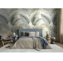 Moderne slaapkamer met groot fotobehang met palmbladeren, een gestoffeerd bed en een houten fauteuil.