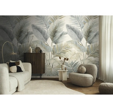 Moderne woonkamer met fotobehang met grote palmbladeren, lichte stoffen bank, donker dressoir en een ronde fauteuil op een houten vloer.