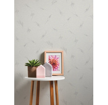 Licht gestructureerd vliesbehang met grafisch lijnenpatroon in een moderne kamer met bijzettafel, succulent en decoratie.