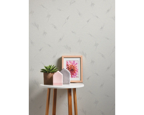 Licht gestructureerd vliesbehang met grafisch lijnenpatroon in een moderne kamer met bijzettafel, succulent en decoratie.