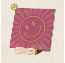 Decoratieve tegel met smiley, goudfolie-accenten en tekst Be Happy and Smile op een houten standaard.