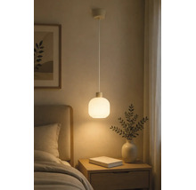 Hanglamp met een ronde kap van mat glas, hangend boven een houten nachtkastje in een slaapkamer.