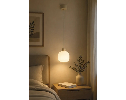Hanglamp met een ronde kap van mat glas, hangend boven een houten nachtkastje in een slaapkamer.