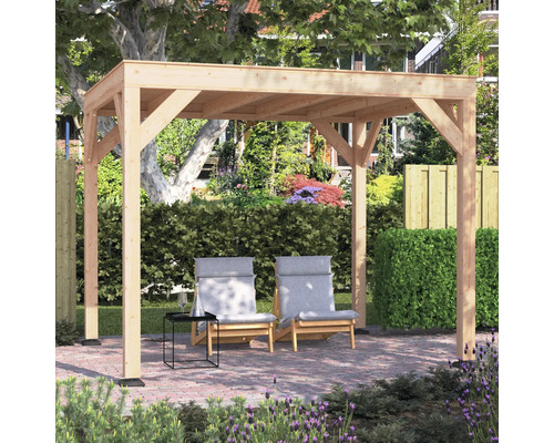 Houten pergola met plat dak in een tuin op een terras met klinkers, twee ligstoelen en een bijzettafeltje voor een heg.