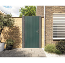 Moderne groene tuindeur met verticale lamellen en grijze palen, gemonteerd tussen een lichte houten schutting en een bakstenen muur op een terras.