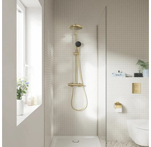 Moderne badkamer met messing douchesysteem, glazen douchewand, beige mozaïektegels en hangend toilet.