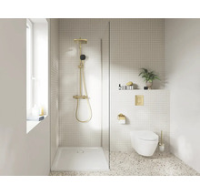Moderne badkamer met inloopdouche, gouden regendouche, witte douchebak, hangend toilet met gouden bedieningsplaat en lichte terrazzovloer.