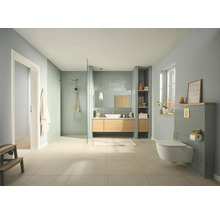 Moderne, lichte badkamer met inloopdouche, houten wastafelmeubel, hangend toilet, groenblauwe tegels en gouden kranen.