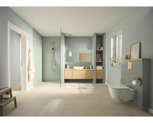 Moderne, lichte badkamer met inloopdouche, houten wastafelmeubel, hangend toilet, groenblauwe tegels en gouden kranen.