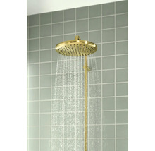 Goudkleurige regendouchekop met stromend water, gemonteerd op een betegelde muur.