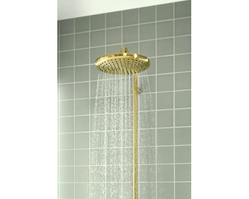 Goudkleurige regendouchekop met stromend water, gemonteerd op een betegelde muur.