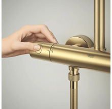 Een hand bedient de regelaar van een GROHE douchethermostaatkraan.