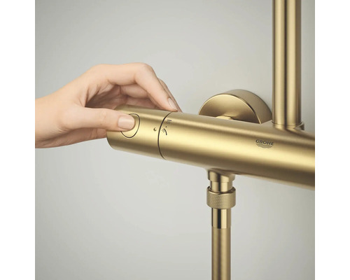 Een hand bedient de regelaar van een GROHE douchethermostaatkraan.