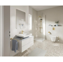 Moderne, lichte badkamer met wit wastafelmeubel, gouden kranen, een inloopdouche en terrazzovloer.