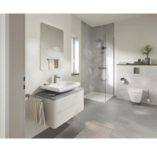 Moderne badkamer met wastafelmeubel, spiegel, inloopdouche en hangend toilet in lichte grijstinten.