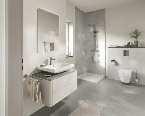 Moderne badkamer met wastafelmeubel, spiegel, inloopdouche en hangend toilet in lichte grijstinten.