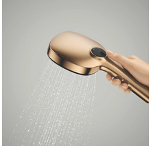 Handdouche met stromende waterstraal en select-knop, vastgehouden door een hand.