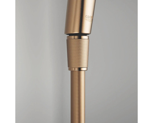 Close-up van een doucheslangaansluiting met gekartelde huls en Grohe Logo.