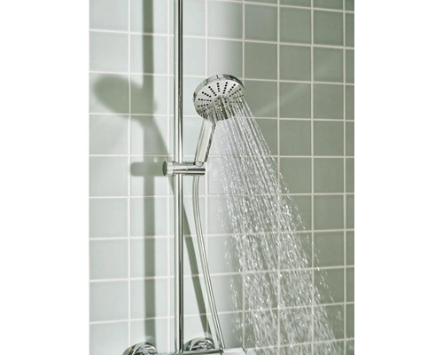 Verchroomde handdouche op een glijstang met stromend water tegen een betegelde wand.