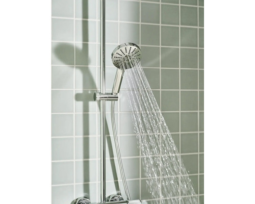 Handdouche met waterstraal op een douchestang voor een betegelde muur.