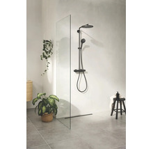 Moderne inloopdouche met glazen douchewand, douchesysteem met hoofddouche en handdouche, grijze tegels en decoratieve planten.