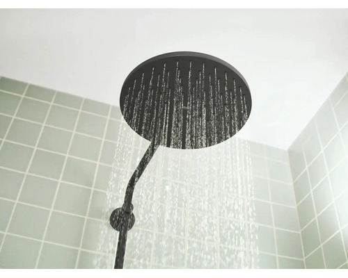 Ronde hoofddouche regendouche met stromend water in de badkamer.