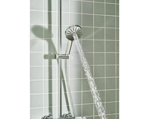 Verchroomde handdouche met stromend water, gemonteerd op een douchestang voor een betegelde wand.