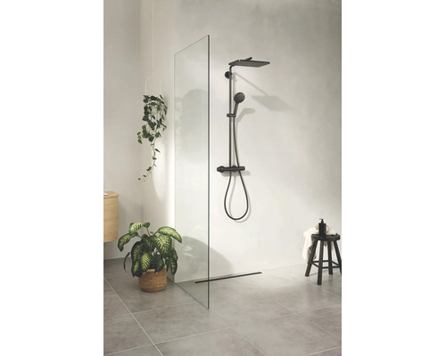 Moderne badkamer met een inloopdouchewand van glas, zwart douchesysteem met regendouche en grijze vloertegels.