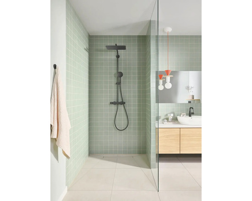 Moderne badkamer met groene wandtegels, inloopdouche met zwart douchesysteem en houten wastafelmeubel.