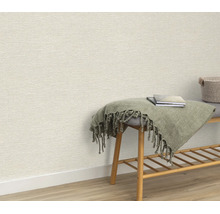 Gestructureerd behang in een interieur met een houten bankje, een mand en een deken voor een muur.