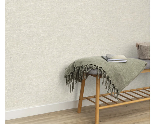 Gestructureerd behang in een interieur met een houten bankje, een mand en een deken voor een muur.