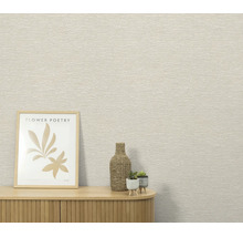 Gestructureerd behang in een interieur met een houten dressoir, een ingelijste afbeelding en kleine decoraties.