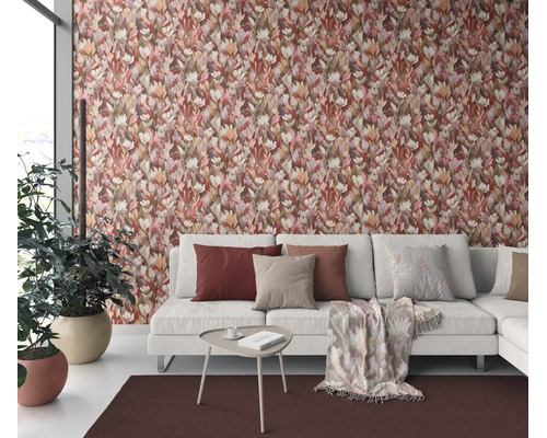Woonkamer met vliesbehang met bloemenpatroon, lichte bank met sierkussens, kleine bijzettafel en plant voor een muur met patroon.