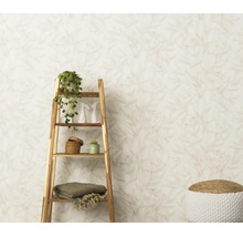 Vliesbehang met bladerpatroon in een lichte woonruimte met houten rek en decoratie.