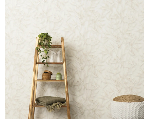 Vliesbehang met bladerpatroon in een lichte woonruimte met houten rek en decoratie.