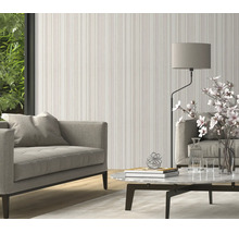 Woonkamer met gestreept behang in een modern interieur met gestoffeerde meubels en een marmeren tafel.