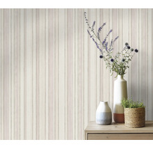 Vliesbehang met verticaal streeppatroon in een woonkamer met houten tafel en bloemenvaas.