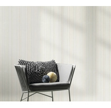 Modern vliesbehang met subtiele strepenstructuur voor een woonsituatie met fauteuil en decoratie.