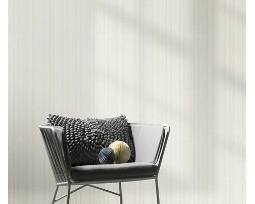 Modern vliesbehang met subtiele strepenstructuur voor een woonsituatie met fauteuil en decoratie.