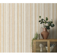 Vliesbehang met verticaal strepenpatroon in een organische look, gecombineerd met een houten kast en decoratieartikelen.