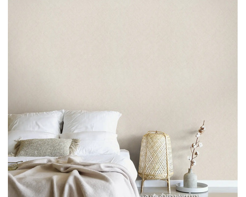 Een minimalistische slaapkamer met gestructureerd behang, een opgemaakt bed en een decoratieve rotan lamp in een natuurlijk design.