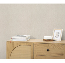 Beige behang met fijne textuur in een woonkamer met een houten dressoir.