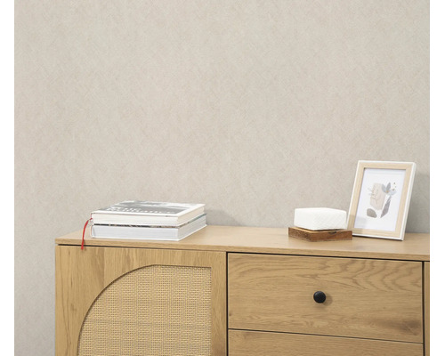 Beige behang met fijne textuur in een woonkamer met een houten dressoir.